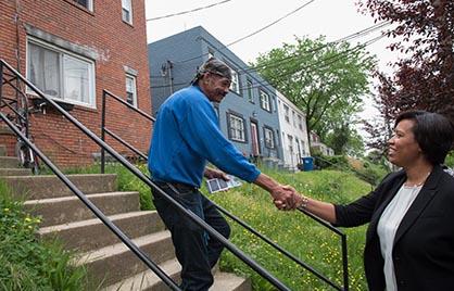 Mayor Bowser shaking the hand of a male resident