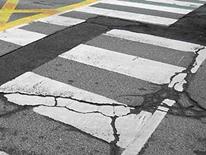 Utility Cut Photo of badly cracked painted street crossing area of a city roadway needing utilities cut off prior to repairs